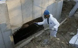 Professional waterproofing the exterior walls of the basement in Oakland, CA